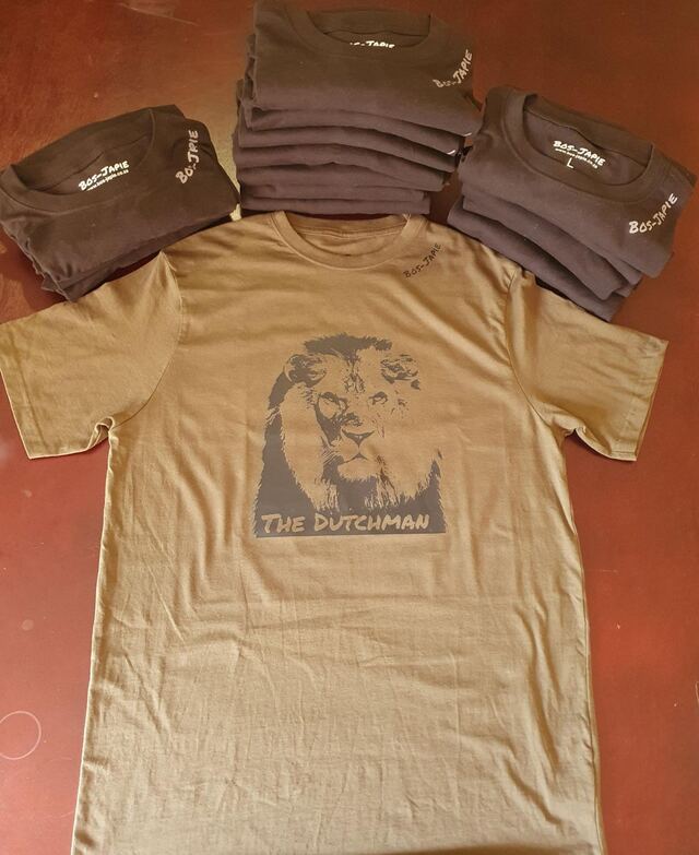 A printed lion shirt on a stack of folded shirts
